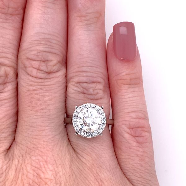lab grown round cut solitaire ring with halo setting in platinum on hand